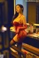 A woman in a red lingerie sitting on a counter.