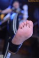 A close up of a person's foot with a band in the background.