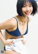 A woman in a blue bra and white panties posing for a picture.