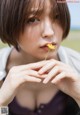 A woman holding a yellow flower in her hand.